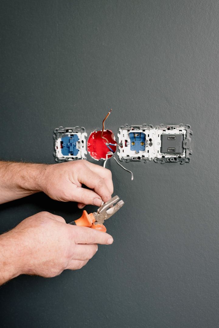 Electrician installing a wall outlet