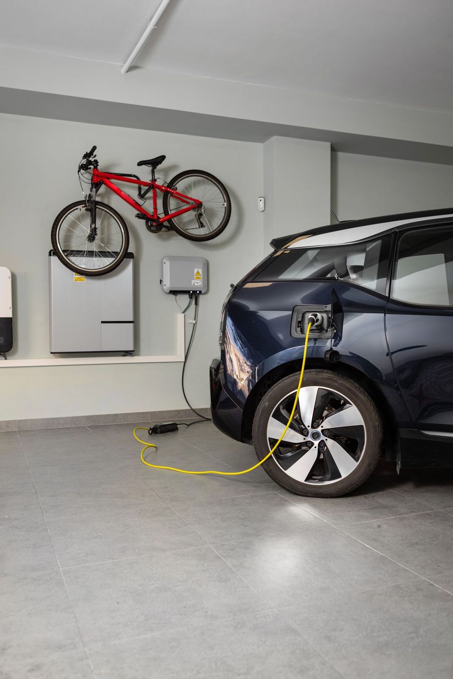 Electric car charging from a wall-mounted EV charger in a home garage