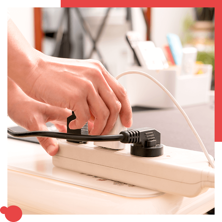 Electrician plugging in and testing a surge protector