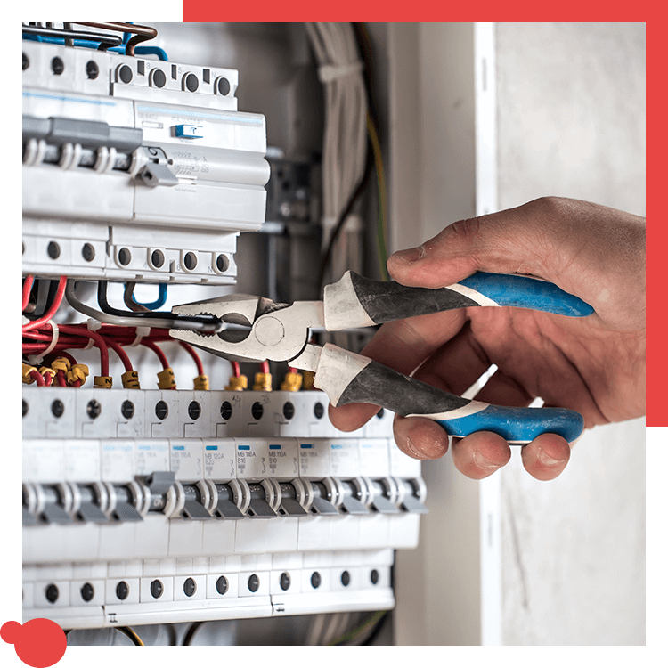 Electrician using pliers on breakers in a panel